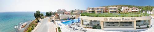 a building on a hill next to the ocean at Aegean Dream Hotel in Karfas