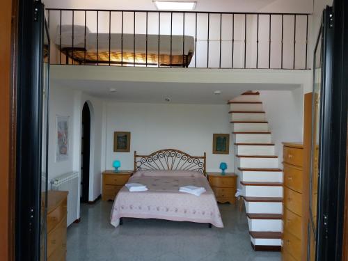 a bedroom with a bed and a staircase with a bunk bed at Roma alla Villa di Pompeo in Ladispoli
