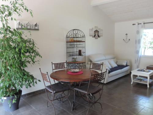 comedor con mesa y sillas y jaula para aves en Maison d'Amis, en Salles