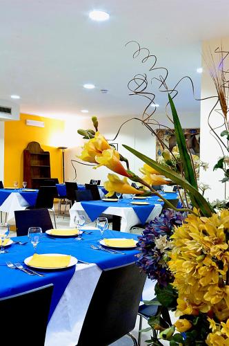 a group of blue tables with yellow flowers on them at City Hotel & Suites in Foligno