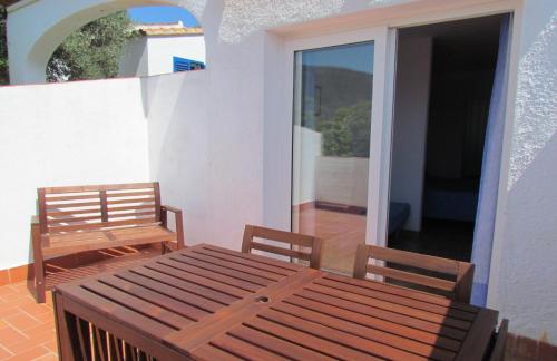 a wooden table and two chairs on a balcony at Carpe Diem Cadaqués in Cadaqués