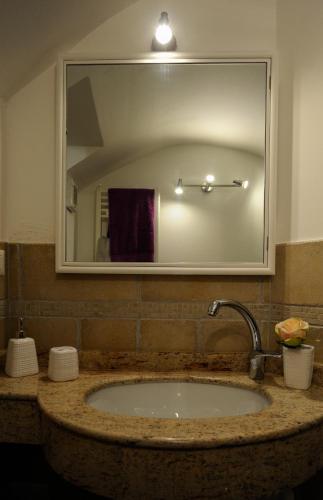 a bathroom sink with a large mirror above it at La Casetta in Lecce