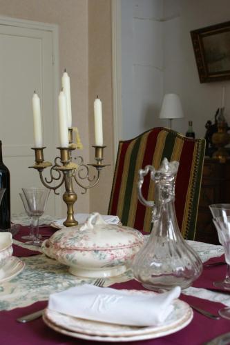 a dining room table with a glass vase and candles at Le Sillon d'Alaric in Lézignan-Corbières