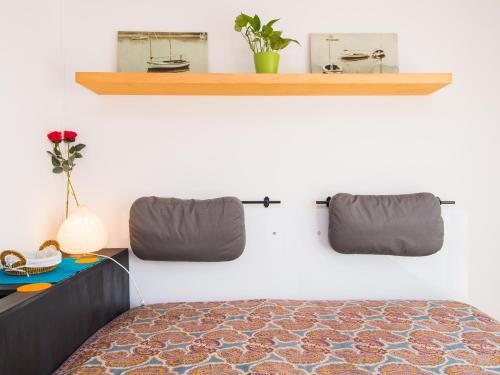 a bedroom with a bed and a shelf on the wall at Sunny Apartments in Sitges