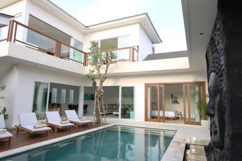 une villa avec une piscine et une maison dans l'établissement Villa Aditi, à Seminyak