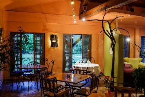 a dining room with tables and chairs and windows at Hotel Active in Szczecinek