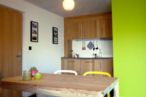 a kitchen with a wooden table and yellow chairs at Iglusaq Lodge in Veysonnaz