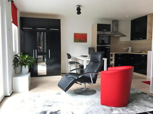 ヘンシュテット・ウルツブルクにあるAll-In-One-Studioのキッチン(黒と赤の椅子、テーブル付)