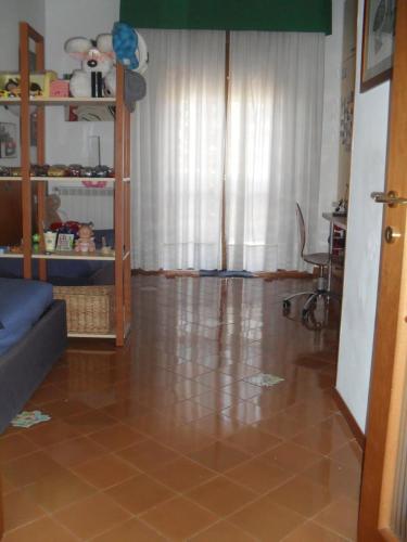 un soggiorno con pavimento piastrellato marrone e finestra. di Casa di Paola a Napoli