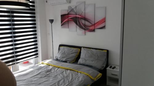 1 dormitorio con 1 cama y una pintura en la pared en White City 1 Apartment, en Belgrado