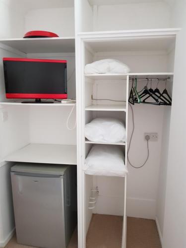 einem Schrank mit einem Computer und einem Schreibtisch mit einem Monitor in der Unterkunft Chelford Guesthouse in Marthall