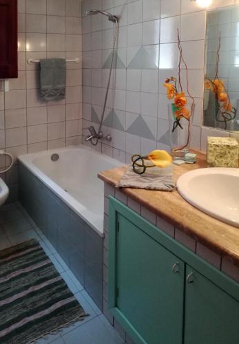 a bathroom with a tub and a sink at Villa Mediterranea in Scopello