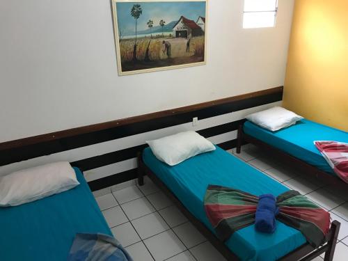 - 2 lits jumeaux dans une chambre avec une photo sur le mur dans l'établissement Hotel Lucena, à Guarabira
