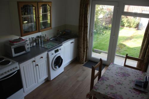 a kitchen with a sink and a washing machine at Inver bay apartment in Tain