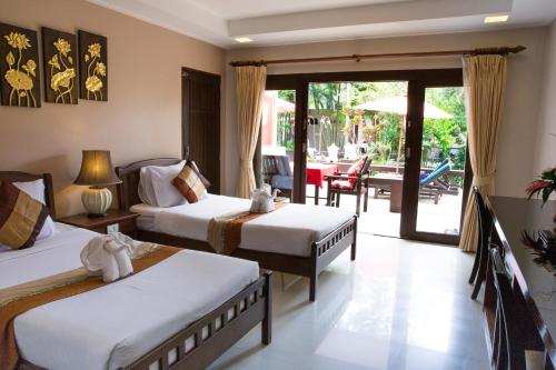 a hotel room with two beds and a patio at The Florist Resort in Mae Nam