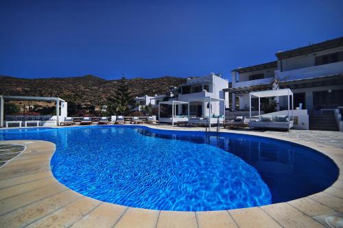uma grande piscina azul com cadeiras e edifícios em Island House Hotel em Mylopotas