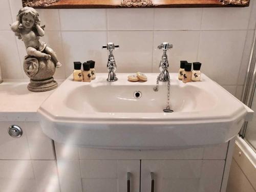 a bathroom sink with a statue of a girl on it at The Star And Eagle Hotel in Goudhurst