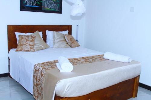 a bedroom with a bed with white sheets and pillows at White Tusk Udawalawe in Udawalawe