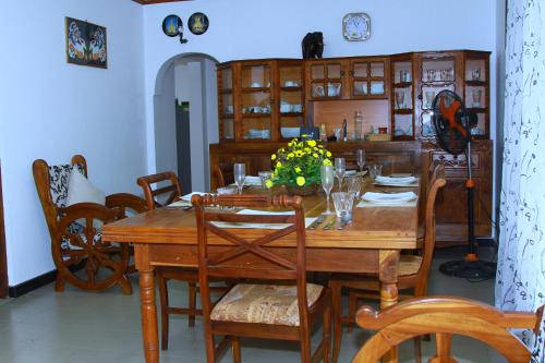 a dining room with a wooden table and chairs at White Tusk Udawalawe in Udawalawe