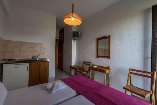 um quarto com uma cama e uma cozinha com uma mesa em Hotel Irini em Skala Potamias