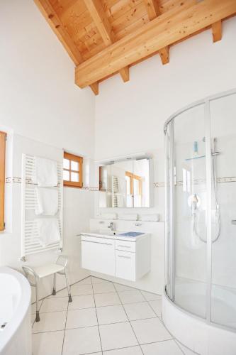 a white bathroom with a shower and a sink at Ferienhaus Angermeier in Oberstdorf