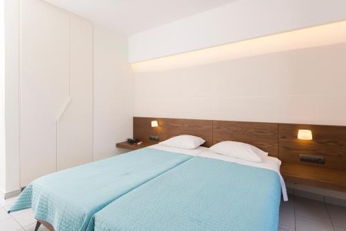 ein Schlafzimmer mit einem Bett mit einer blauen Decke in der Unterkunft Long Beach Kokkari Samos in Kokkari