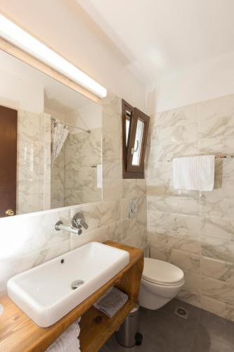 ein weißes Badezimmer mit Waschbecken und Toilette in der Unterkunft Long Beach Kokkari Samos in Kokkari
