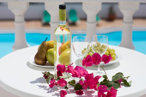 - une table avec des fruits, une bouteille de vin et des fleurs dans l'établissement Apartamentos Tisalaya, à Puerto del Carmen