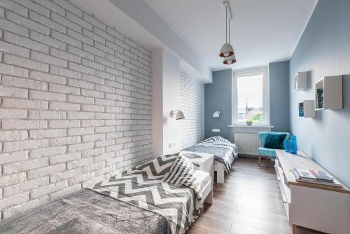 een kamer met 2 bedden en een bakstenen muur bij Stylish Apartment Posnania City Center in Poznań