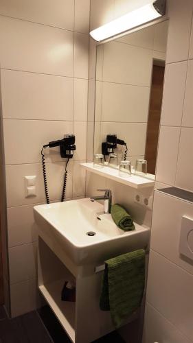 ein Badezimmer mit Waschbecken und Spiegel in der Unterkunft Pension Jägerhof in Mallnitz