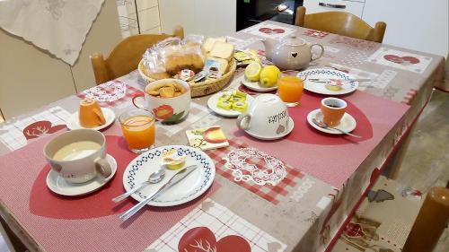 a table with a pink table cloth with cups and plates at Rosy B&B in Alghero