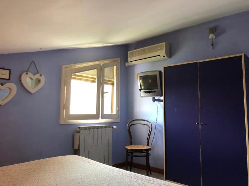 ein Schlafzimmer mit einer blauen Wand, einem Bett und einem Fenster in der Unterkunft CAFFELETTI friendly B&B in Torre del Lago Puccini