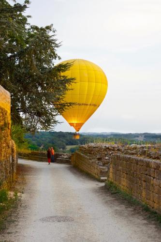 a yellow balloon is flying over a road at La Dommerie-Gite de charme in Domme