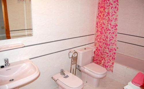a bathroom with a sink and a toilet and a shower curtain at Casa Jasmin 1 in Riumar
