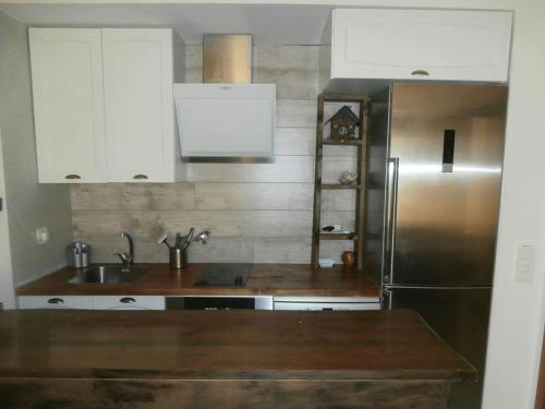 a kitchen with white cabinets and a stainless steel refrigerator at Apartamento Edificio Serraneu. Sierra Nevada. Granada in Sierra Nevada