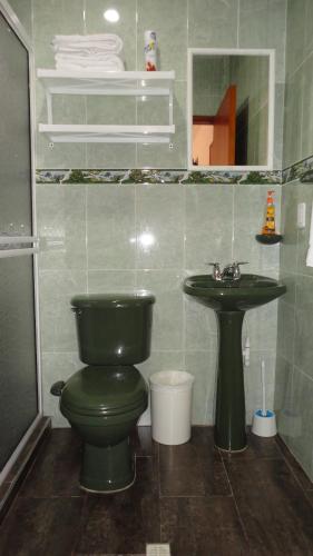 a bathroom with a green toilet and a sink at Posada Nativa Miss Nova in San Andrés
