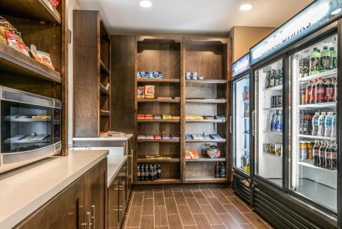 a kitchen with a refrigerator and shelves with food at Comfort Suites Florence - Cincinnati South in Florence