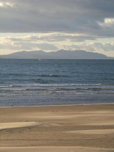 a beach with the ocean and mountains in the background at Horizon Hotel in Ayr