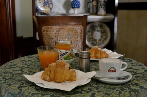 een tafel met een bord gebak en een kopje jus d'orange bij Dimora La Rosa Barocca in Palazzolo Acreide