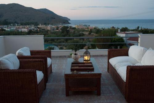 a patio with couches and a table with a view at Villa Amfimala in Georgioupolis