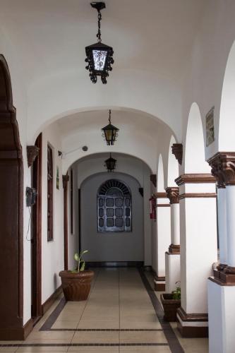 an empty hallway with a potted plant in a building at Hotel Colonial in Manzanillo