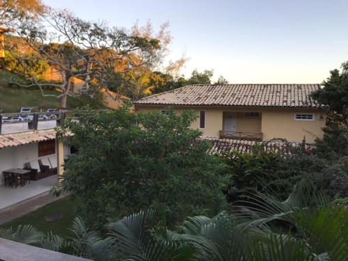 a view of a house with chairs and trees at Praia da Ferradurinha Guest House in Búzios