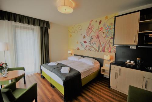 ギェネシュディアーシュにあるA Mi Házunkのベッドとテーブルが備わるホテルルームです。