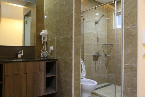 uma casa de banho com um chuveiro, um WC e um lavatório. em 德瑞旅店Direct Hotel em Kaohsiung