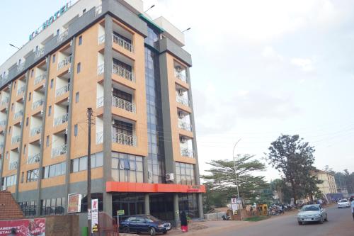 a tall building with cars parked in front of it at Hotel OK Kampala in Kampala