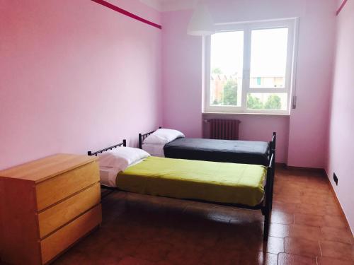 2 Betten in einem Zimmer mit rosa Wänden und einem Fenster in der Unterkunft Juventus (Allianz) stadium apartment in Turin