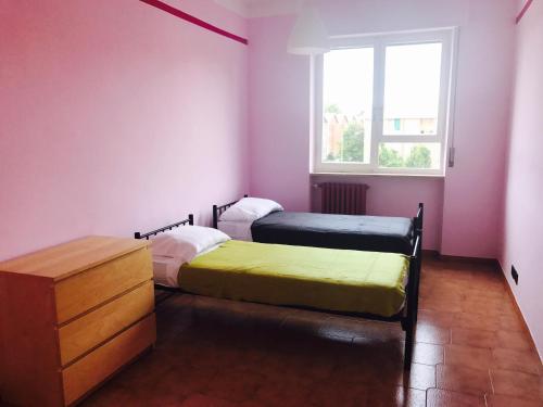 2 camas en una habitación con paredes rosas y ventana en Juventus (Allianz) stadium apartment, en Turín