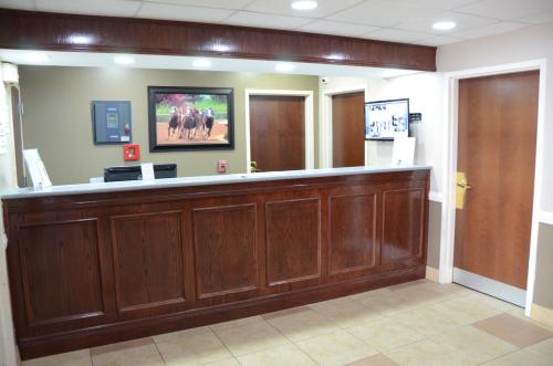 a waiting room with a large wooden reception counter at Super 8 by Wyndham Louisville/Expo Center in Louisville