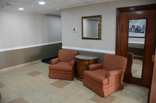 a waiting room with two chairs and a mirror at Super 8 by Wyndham Louisville/Expo Center in Louisville