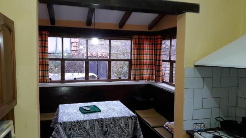 ein Zimmer mit einem Tisch in einer Küche mit einem Fenster in der Unterkunft Casa en Las Sierras de Cordoba in La Falda